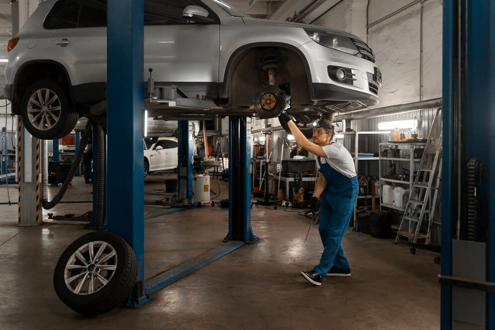 Mecánico trabajando en un automóvil elevado