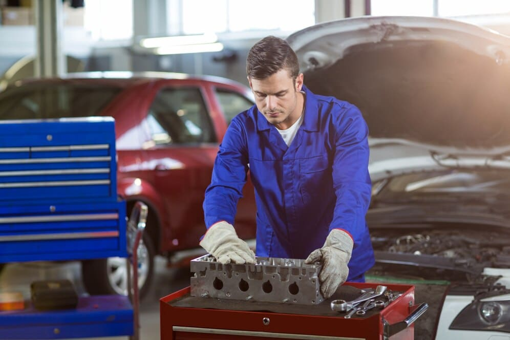 Mecánico examinando una pieza de motor